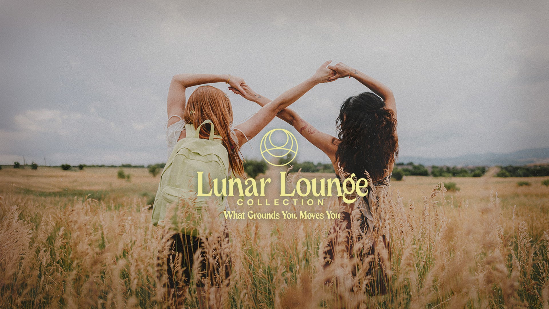 Two people holding hands in a field wearing pastel jansport backpacks with 'Lunar Lounge Collection' text overlay.
