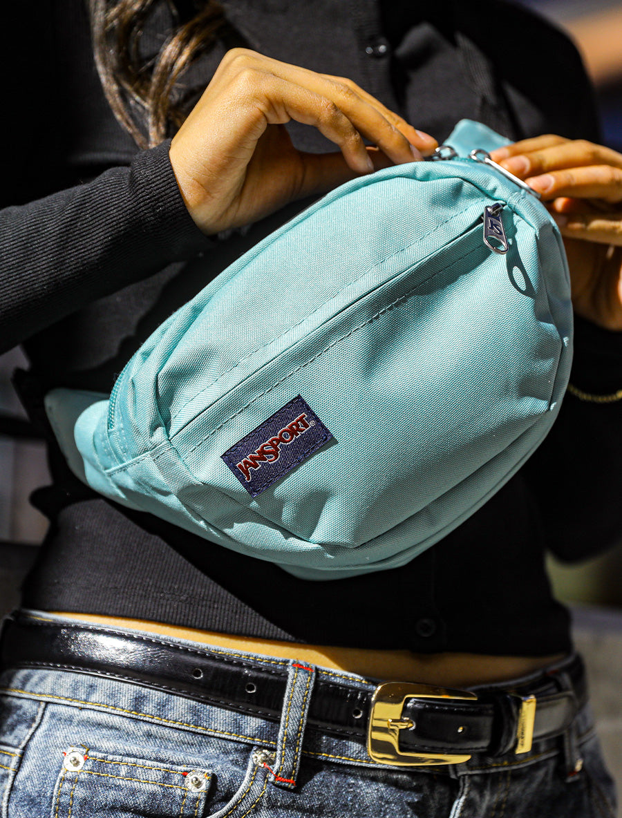 A light blue cross body JanSport Waist Pack