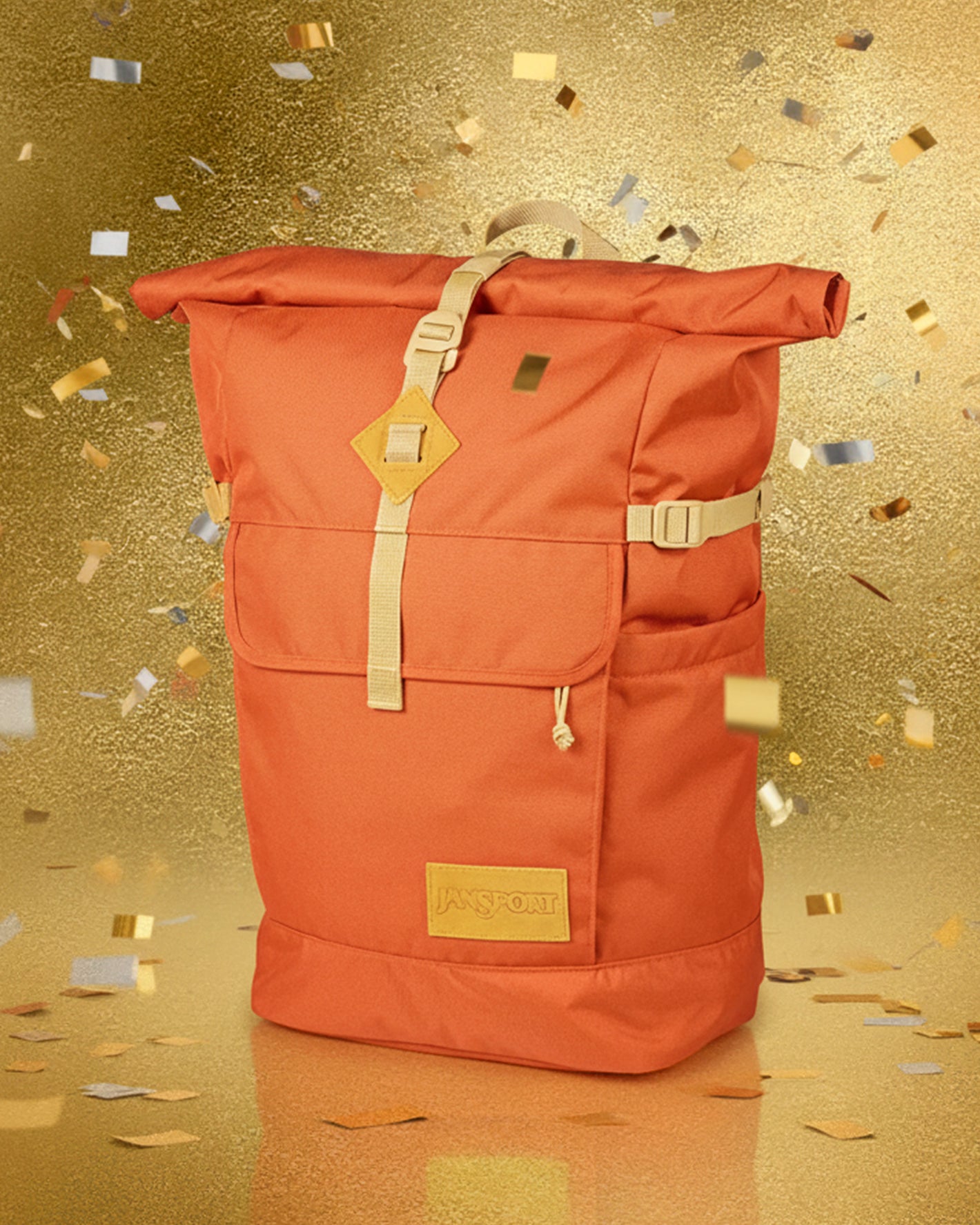 Orange Jansport hatchet backpack with gold accents on a gold glittery background